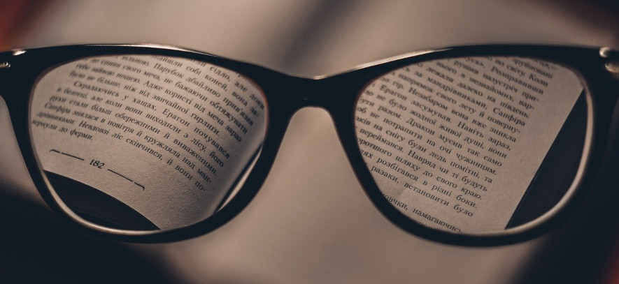 svarta glasögonbågar, bok med text